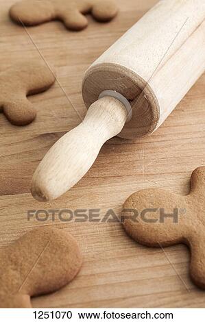 Unfrosted gingerbread men on a wood table with a rolling pin, close-up View Large Photo Image Stock Image - Unfrosted gingerbread men on a wood table with a rolling pin, close-up. Fotosearch