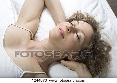 Woman relaxing on bed View Large Photo Image Stock Image - Woman relaxing on bed. Fotosearch
