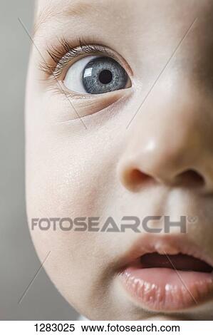 Stock Photography - A baby boy looking curiously into the camera, extreme close-up. Fotosearch