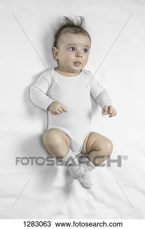 A baby boy lying on his back and day dreaming View Large Photo Image Stock Image - A baby boy lying on his back and day dreaming. Fotosearch