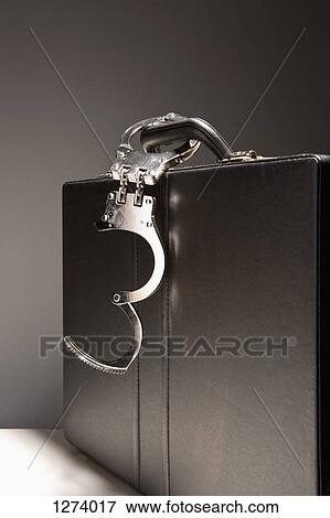 A briefcase with handcuffs attached to the handle View Large Photo Image Stock Photo - A briefcase with handcuffs attached to the handle. Fotosearch