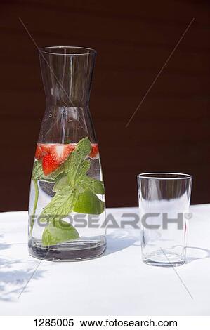 A carafe of water with sliced strawberries and mint leaves View Large Photo Image Stock Photography - A carafe of water with sliced strawberries and mint leaves. Fotosearch