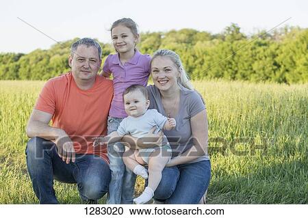 A family portrait taken in a field in a rural setting View Large Photo Image Stock Image - A family portrait taken in a field in a rural setting. Fotosearch
