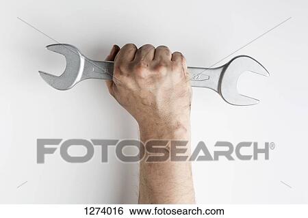Stock Photograph - A fist holding a wrench up triumphantly. Fotosearch