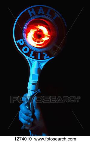 Stock Image - A hand holding a police warning sign with the German Halt Polizei on it. Fotosearch