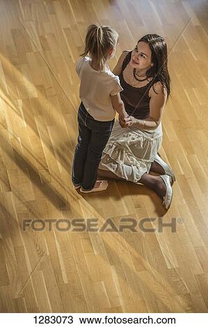 Stock Image - A mother and daughter, face to face, holding hands. Fotosearch