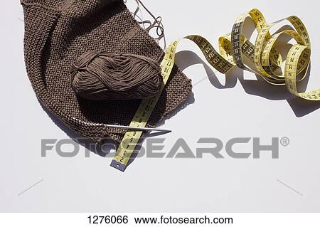 A piece of knitting with ball of yarn, measuring tape and a knitting needle View Large Photo Image Stock Photograph - A piece of knitting with ball of yarn, measuring tape and a knitting needle. Fotosearch