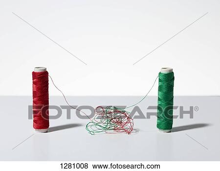 Stock Photo - A pile of tangled thread between two spools of thread. Fotosearch