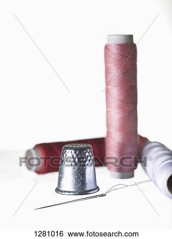 A shiny thimble and threaded needle with three spools of thread View Large Photo Image Stock Photograph - A shiny thimble and threaded needle with three spools of thread. Fotosearch