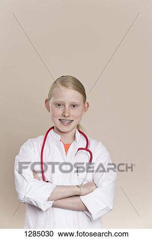 Stock Image - A smiling girl wearing a lab coat with a stethoscope around her neck. Fotosearch