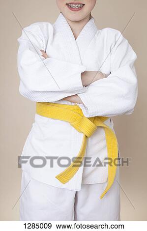 A smiling girl with arms crossed wearing martial arts uniform with yellow belt View Large Photo Image Stock Photo - A smiling girl with arms crossed wearing martial arts uniform with yellow belt. Fotosearch