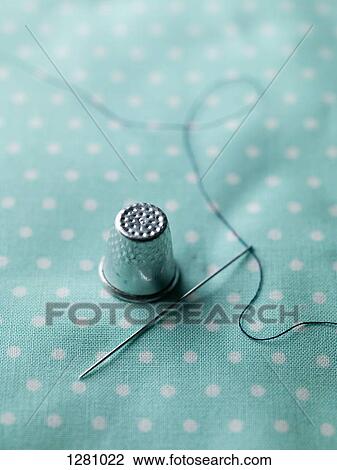 A threaded needle and thimble on top of polka dotted fabric View Large Photo Image Stock Image - A threaded needle and thimble on top of polka dotted fabric. Fotosearch