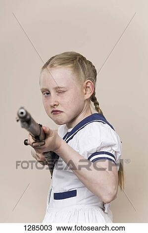A tough girl wearing a sailor dress aiming a rifle at the camera View Large Photo Image Stock Image - A tough girl wearing a sailor dress aiming a rifle at the camera. Fotosearch