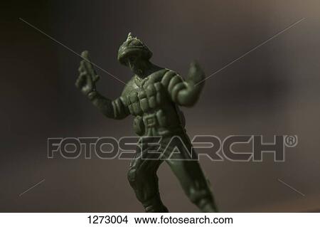 A toy solider holding a gun with arms raised up in surrender View Large Photo Image Picture - A toy solider holding a gun with arms raised up in surrender. Fotosearch