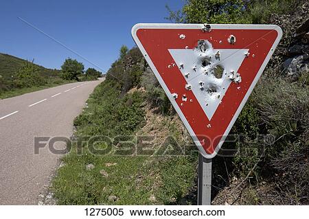 A yield sign with bullet holes in it posted on a remote highway View Large Photo Image Stock Photography - A yield sign with bullet holes in it posted on a remote highway. Fotosearch