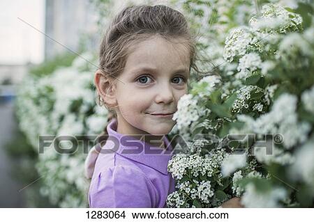 A young girl smelling flowers View Large Photo Image Picture - A young girl smelling flowers. Fotosearch