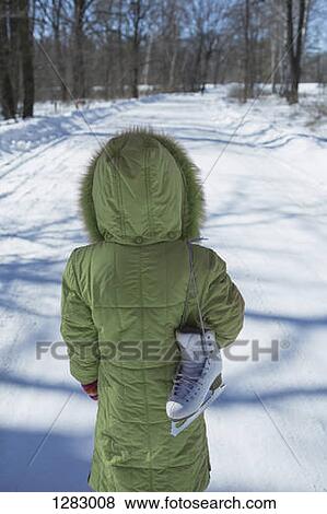 A young girl standing on a snowy road with an ice skate slung over her shoulder View Large Photo Image Stock Photo - A young girl standing on a snowy road with an ice skate slung over her shoulder. Fotosearch