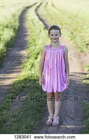 A young smiling girl standing on a dirt road in the country View Large Photo Image Stock Image - A young smiling girl standing on a dirt road in the country. Fotosearch