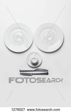 Stock Photo - Anthropomorphic face made from plates, glasses, cup and knives. Fotosearch