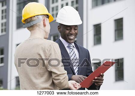 Businessman happily giving directions to manual worker View Large Photo Image Stock Image - Businessman happily giving directions to manual worker. Fotosearch