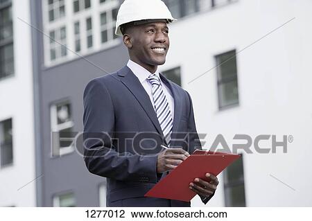 Businessman happily overseeing his work View Large Photo Image Stock Image - Businessman happily overseeing his work. Fotosearch