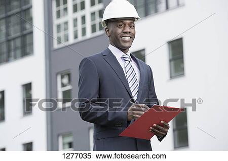 Stock Photography - Businessman happily overseeing his work. Fotosearch
