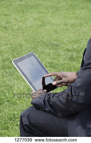 Stock Photo - Businessman using digital tablet. Fotosearch