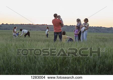 Families relaxing in a field in a rural setting View Large Photo Image Picture - Families relaxing in a field in a rural setting. Fotosearch