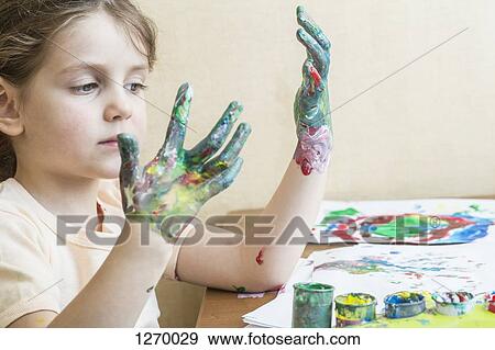 Girl looking at her painted hands View Large Photo Image Stock Photo - Girl looking at her painted hands . Fotosearch