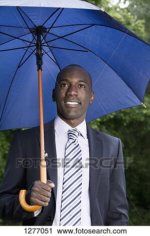 Happy businessman holding umbrella View Large Photo Image Stock Image - Happy businessman holding umbrella. Fotosearch
