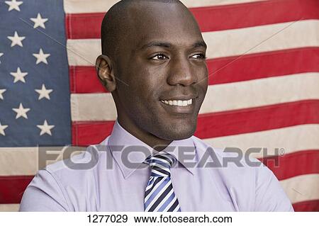 Stock Photo - Happy businessman in front of American flag. Fotosearch