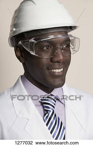 Laboratory worker wearing hard hat, protective goggles and lab coat View Large Photo Image Stock Image - Laboratory worker wearing hard hat, protective goggles and lab coat. Fotosearch