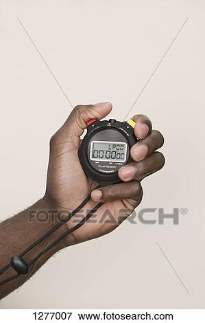 Stock Photo - Man holding digital stopwatch. Fotosearch