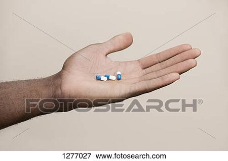 Man holding out three drug capsules View Large Photo Image Stock Photo - Man holding out three drug capsules. Fotosearch