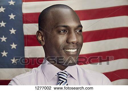 Stock Image - Man in front of American flag. Fotosearch