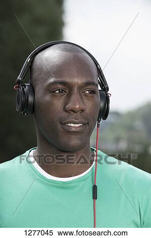 Man listening to music on headphones View Large Photo Image Stock Photography - Man listening to music on headphones. Fotosearch