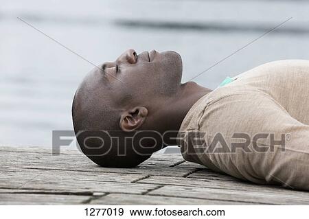 Man napping on decking by lake View Large Photo Image Stock Photo - Man napping on decking by lake. Fotosearch