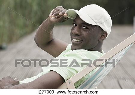 Man relaxing on deck chair View Large Photo Image Stock Photo - Man relaxing on deck chair. Fotosearch