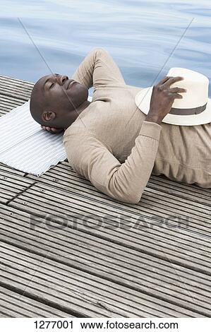 Man relaxing on decking View Large Photo Image Stock Image - Man relaxing on decking. Fotosearch