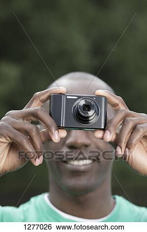 Man taking photograph with digital camera View Large Photo Image Stock Photograph - Man taking photograph with digital camera. Fotosearch