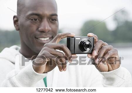 Man using digital camera View Large Photo Image Stock Image - Man using digital camera. Fotosearch