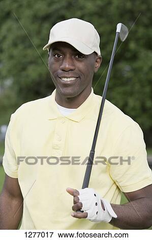 Portrait of man holding golf club View Large Photo Image Stock Photo - Portrait of man holding golf club. Fotosearch