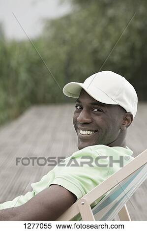 Portrait of man relaxing on deck chair View Large Photo Image Stock Photography - Portrait of man relaxing on deck chair . Fotosearch