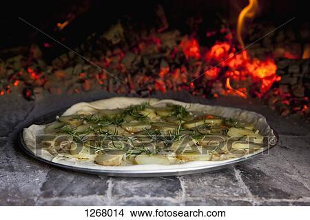 Potato and rosemary pizza in brick oven View Large Photo Image Picture - Potato and rosemary pizza in brick oven. Fotosearch