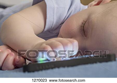 Sleeping baby with hand on smart phone View Large Photo Image Stock Image - Sleeping baby with hand on smart phone. Fotosearch
