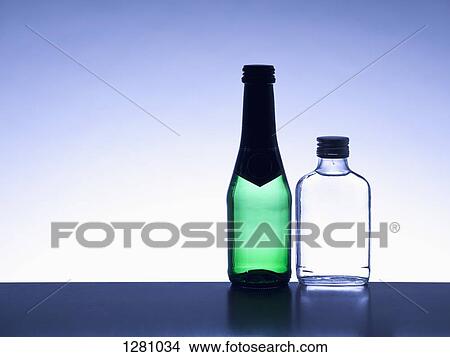 Two miniature bottles of alcohol side by side without labels, back lit View Large Photo Image Picture - Two miniature bottles of alcohol side by side without labels, back lit. Fotosearch