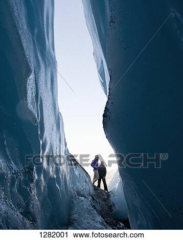 Two women stand looking into crevasse at Worthington Glacier, Alaska, USA View Large Photo Image Stock Image - Two women stand looking into crevasse at Worthington Glacier, Alaska, USA. Fotosearch