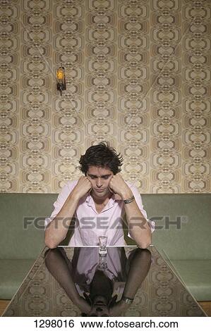 A depressed man looking down at a shot glass View Large Photo Image Stock Photograph - A depressed man looking down at a shot glass. Fotosearch