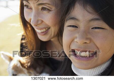 A grinning mother and daughter with dog, close-up View Large Photo Image Stock Image - A grinning mother and daughter with dog, close-up. Fotosearch