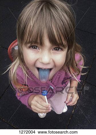 A little girl holding a blue sucker and showing off her blue tongue proudly View Large Photo Image Picture - A little girl holding a blue sucker and showing off her blue tongue proudly. Fotosearch